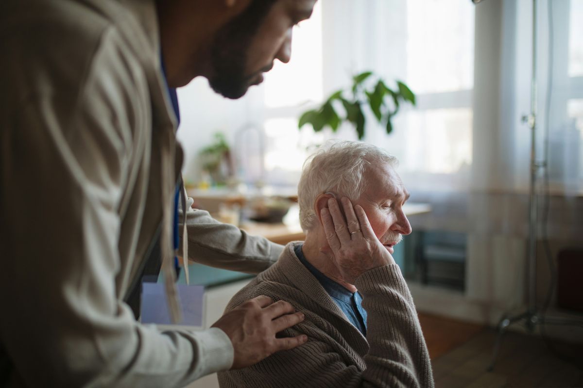 Young man talking to elderly man